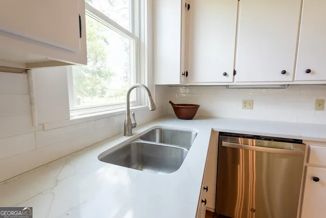 an empty room with windows and chandelier fan