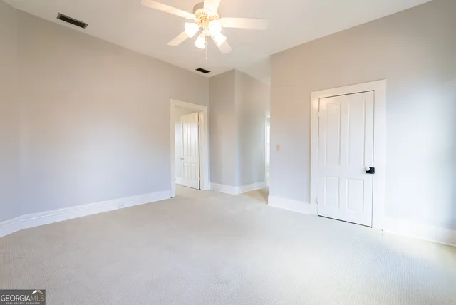 a dining room with furniture a potted plant and wooden floor