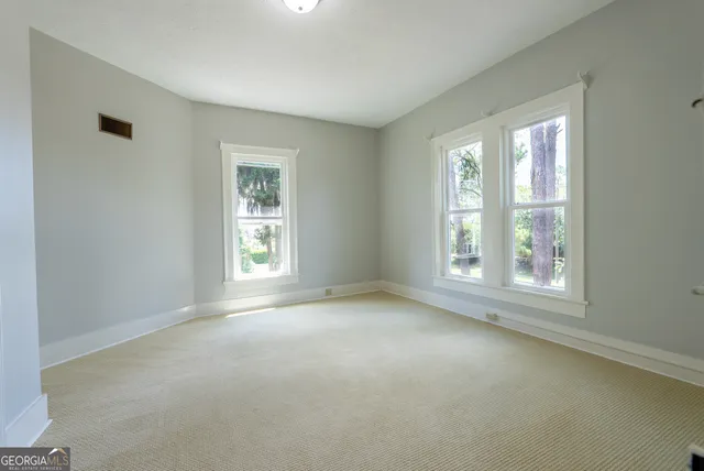 a kitchen with stainless steel appliances a stove a sink a dining table and chairs with wooden floor