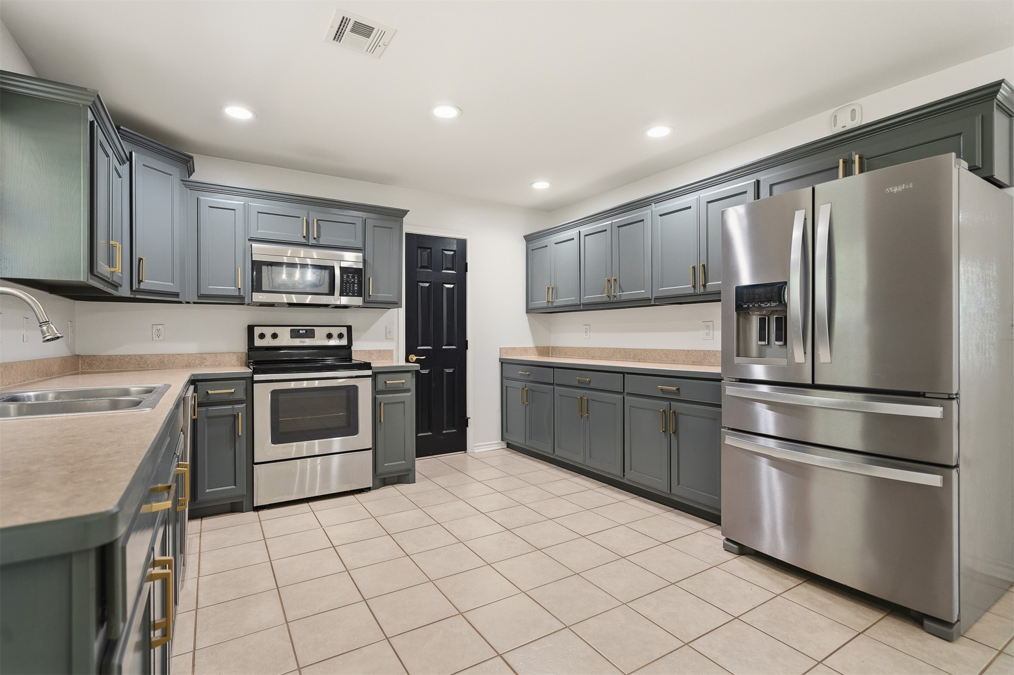 831 Barrons Ridge Wilson, OK 73463 - Photo 6 of 47 Expansive kitchen featuring abundant gray cabinetry with gold-tone hardware, stainless steel appliances, light-toned countertops, and neutral tile flooring
