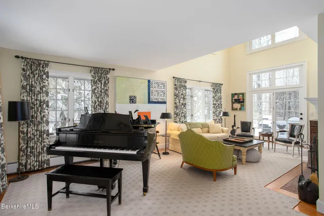 a living room with furniture and a piano