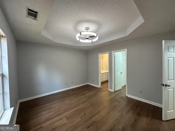 an empty room with wooden floor and window