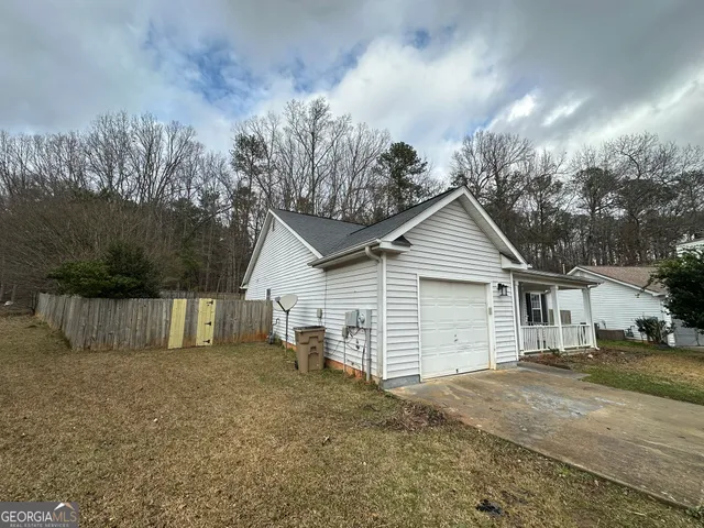 a view of a house with a yard and large tree