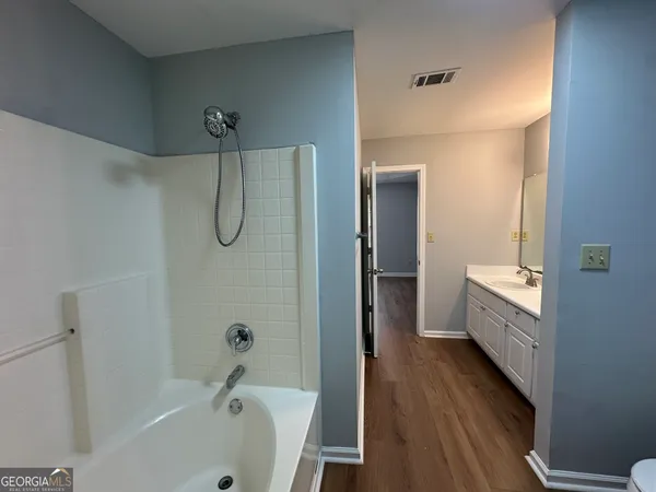 a bathroom with a tub a sink and a mirror