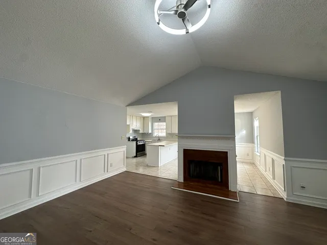 a view of empty room with wooden floor and fireplace