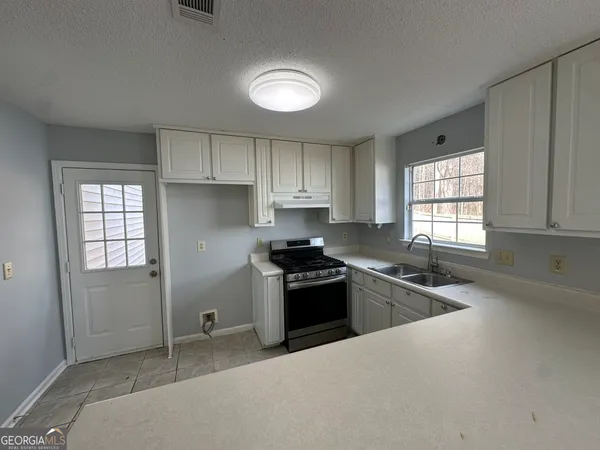 a kitchen that has a sink and a stove in it