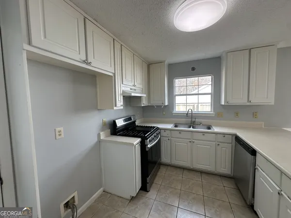 a kitchen with stainless steel appliances granite countertop a sink stove and cabinets