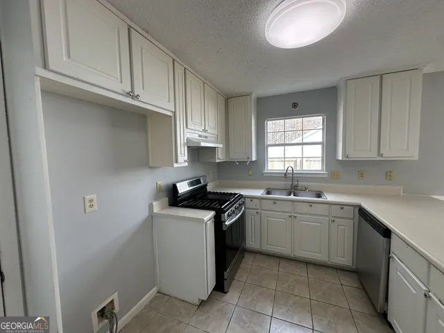 a kitchen with stainless steel appliances granite countertop a sink stove and cabinets