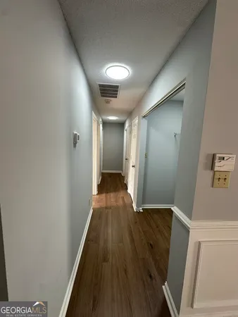 a view of a hallway with wooden floor