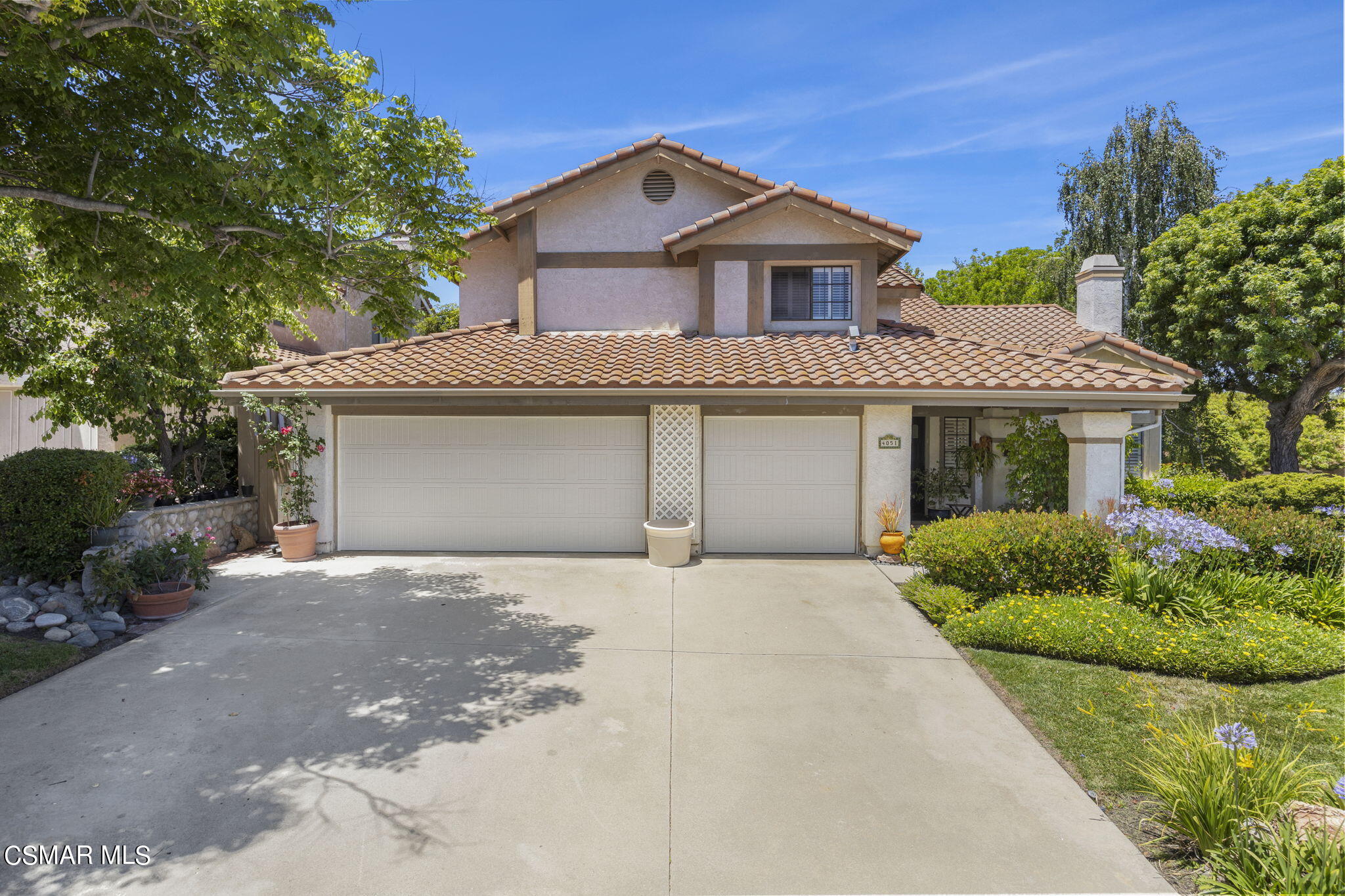 a front view of a house with a garden and garage