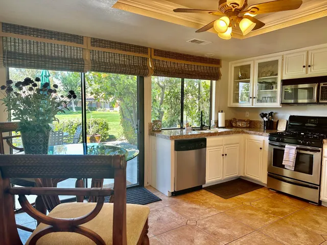 a kitchen with stainless steel appliances granite countertop a refrigerator a stove a sink dishwasher and a refrigerator with wooden floor