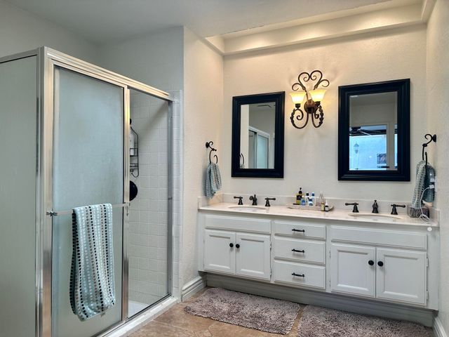 a bathroom with a granite countertop shower and a sink