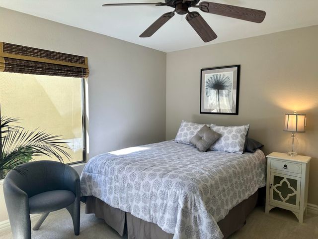 a bedroom with a large bed and a chandelier fan