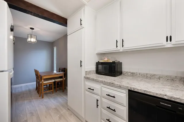 a kitchen with granite countertop cabinets stainless steel appliances and wooden floor