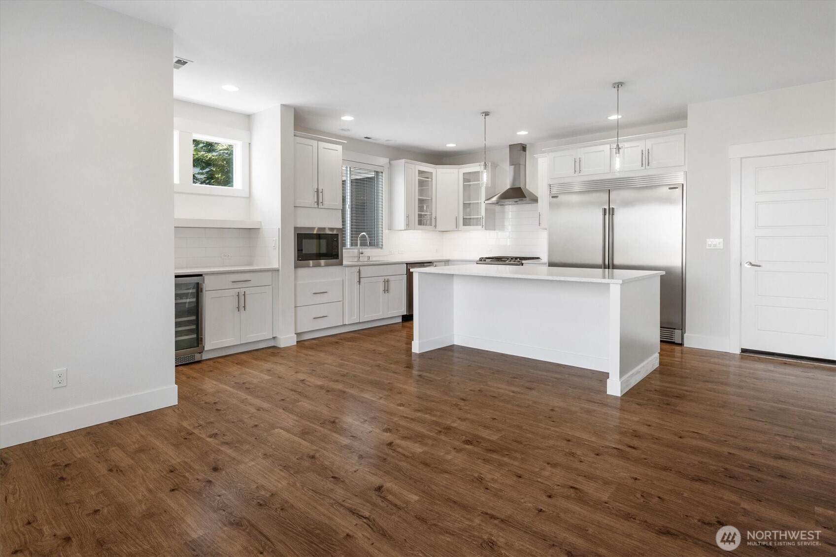 8711 27th Street East Edgewood, WA 98371 - Photo 12 of 40 a large kitchen with cabinets and wooden floor