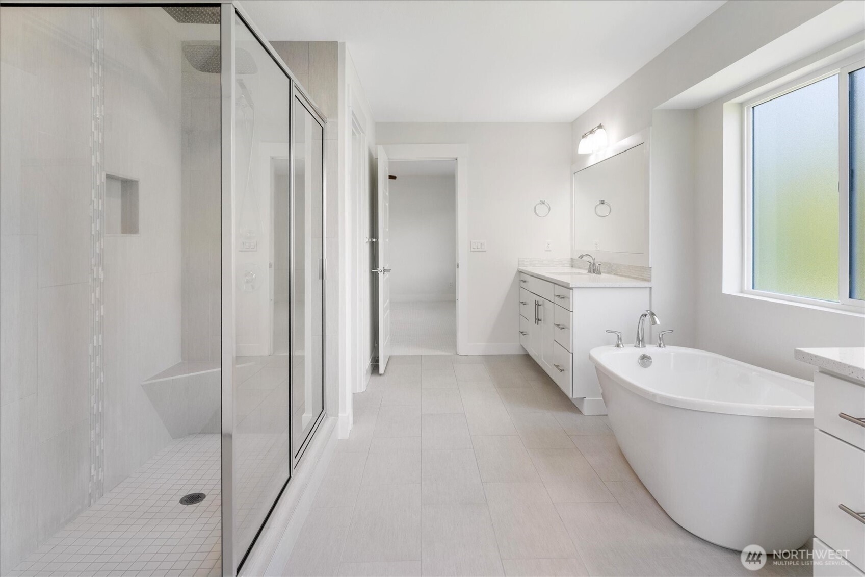 8711 27th Street East Edgewood, WA 98371 - Photo 25 of 40 a spacious bathroom with a double vanity sink a mirror and a bathtub