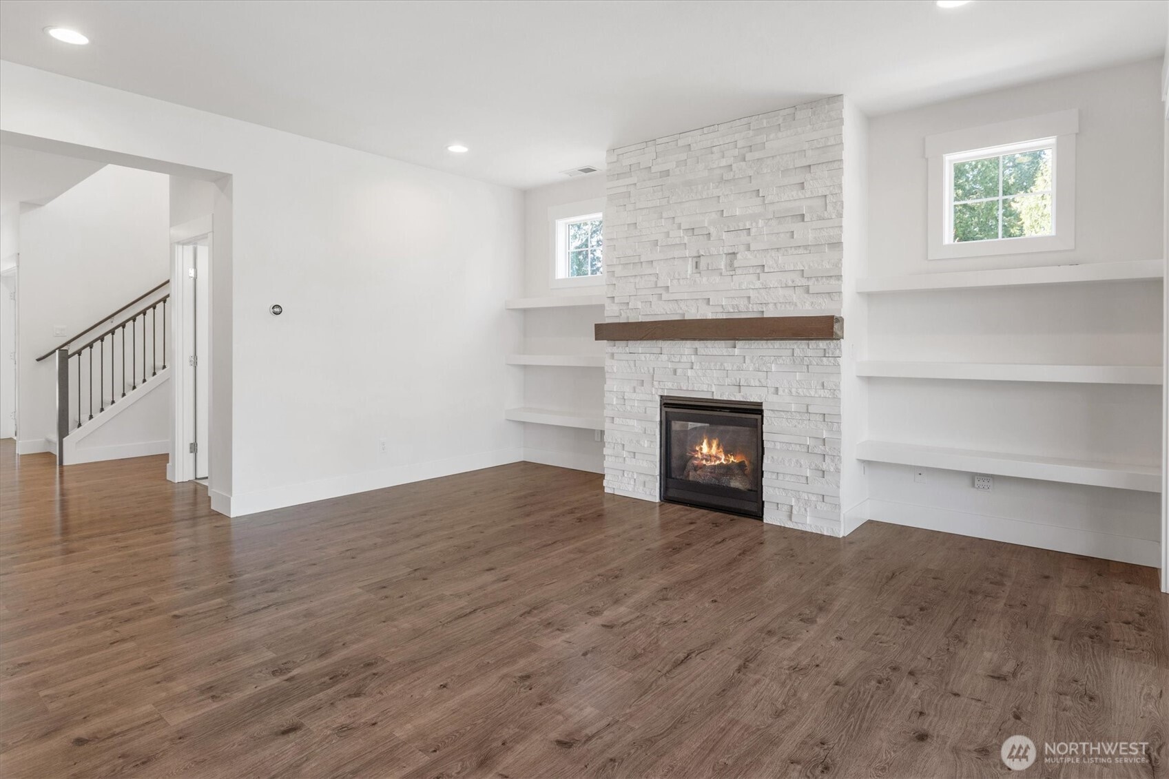 8711 27th Street East Edgewood, WA 98371 - Photo 5 of 40 a view of an empty room with wooden floor and a fireplace