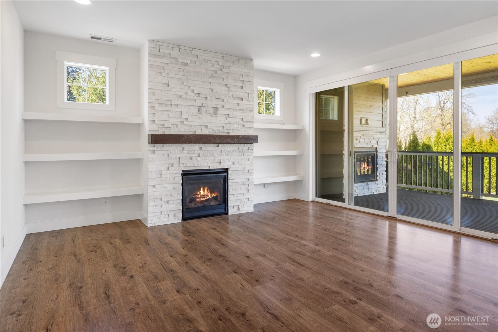 8711 27th Street East Edgewood, WA 98371 - Photo 6 of 40 a view of empty room with wooden floor and fireplace