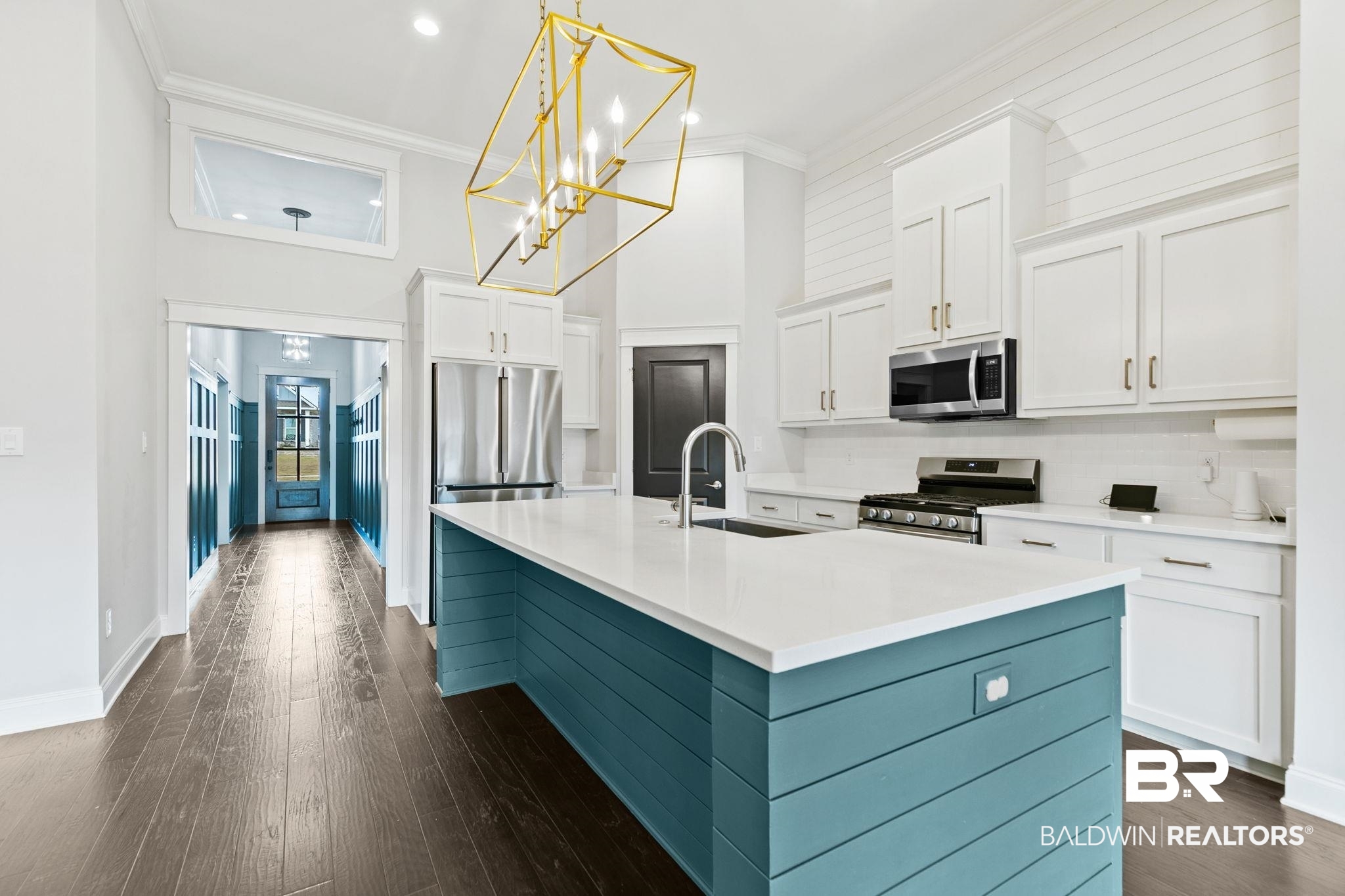 31654 Canopy Loop Daphne, AL 36527 - Photo 13 of 64 Dual tone kitchen featuring a center island with sink, stainless steel appliances, dark wood-style floors, suspended lighting, and crown molding