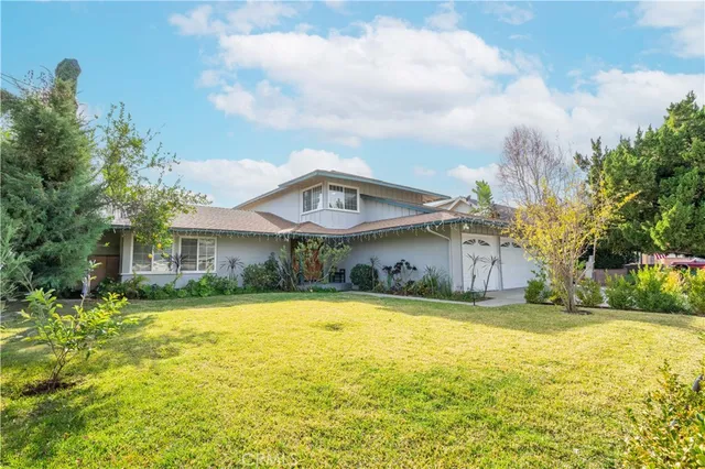 a view of a house with a swimming pool and a yard