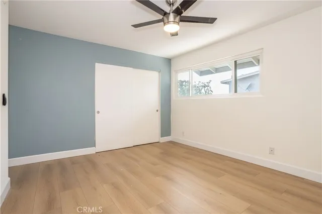 an empty room with a window and a ceiling fan