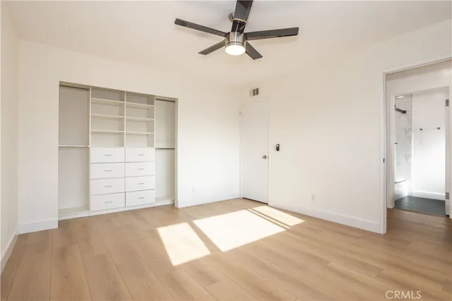 an empty room with closet and fan