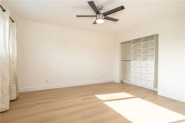 an empty room with cabinet and a ceiling fan