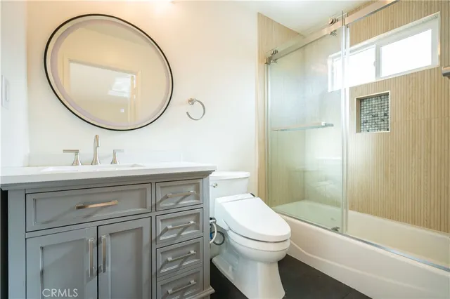 a bathroom with a sink a mirror a toilet and a shower