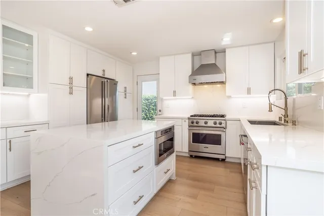 a kitchen with stainless steel appliances a stove a sink and a refrigerator