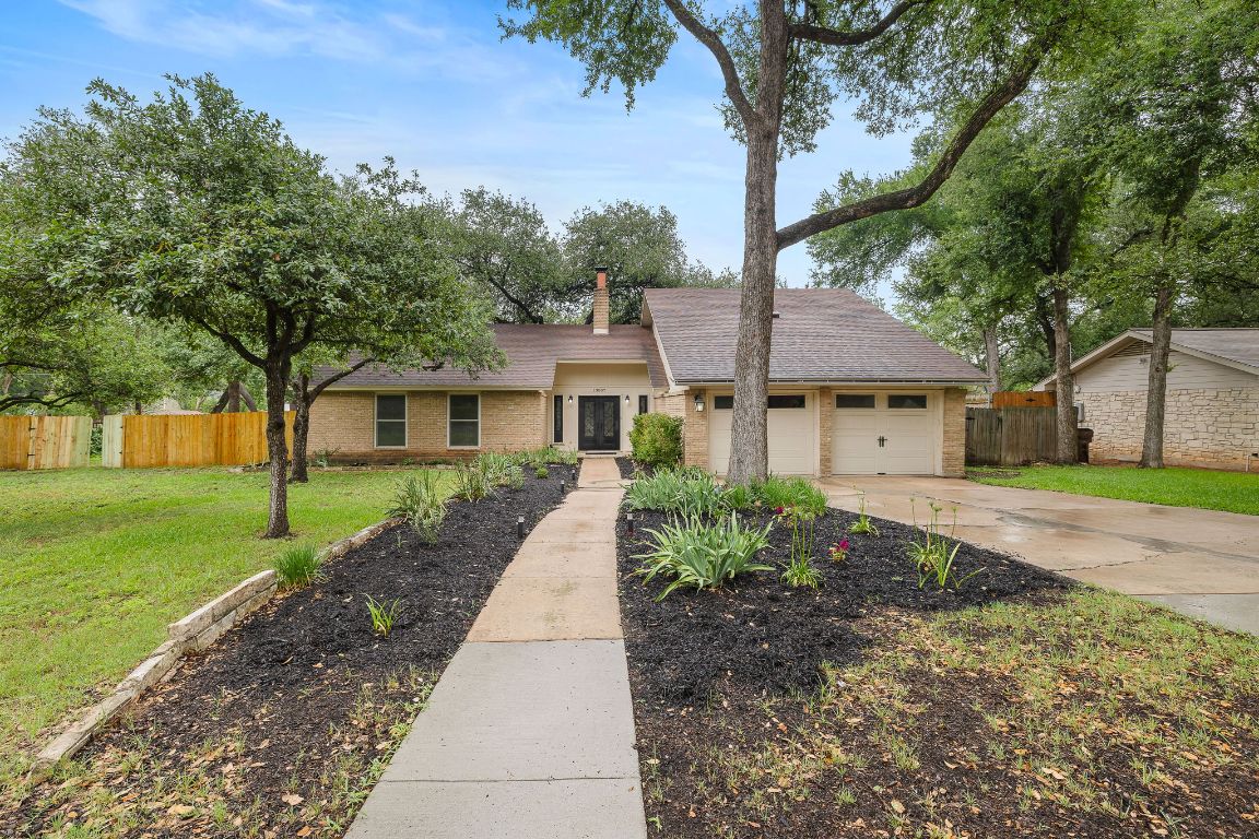 a front view of a house with a yard and trees