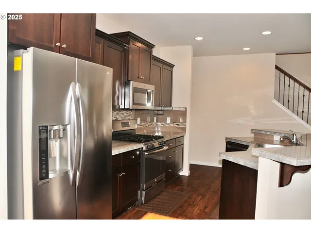 a kitchen with stainless steel appliances a refrigerator sink and stove