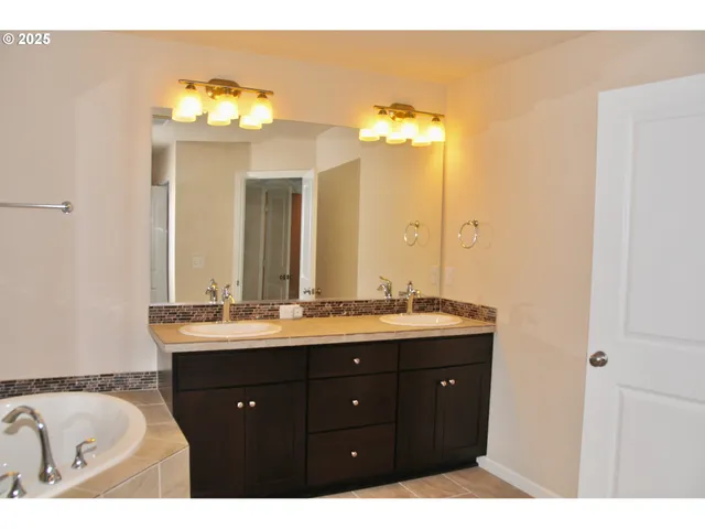 a bathroom with a double vanity sink and a mirror