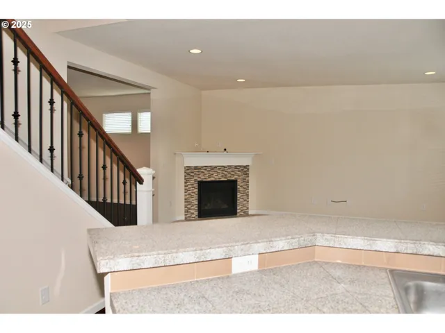 a view of an empty room and staircase