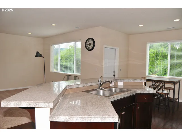 a kitchen with a sink a large window and a dining table with garden view