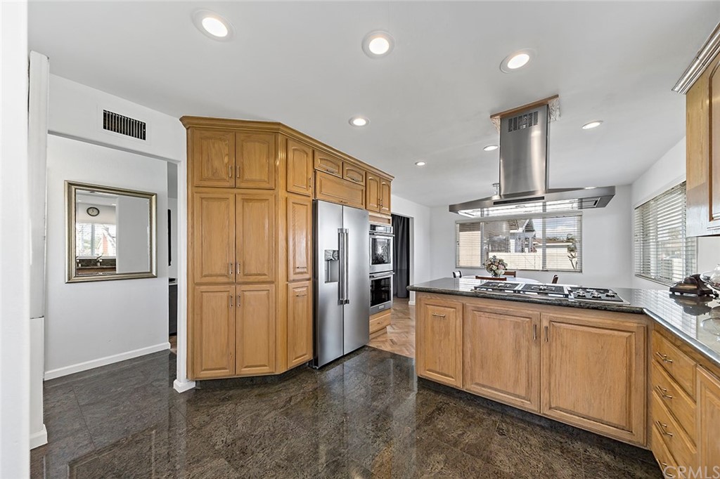 525 East 246th Street Carson, CA 90745 - Photo 11 of 41 a kitchen with stainless steel appliances granite countertop a refrigerator a sink a stove and white cabinets
