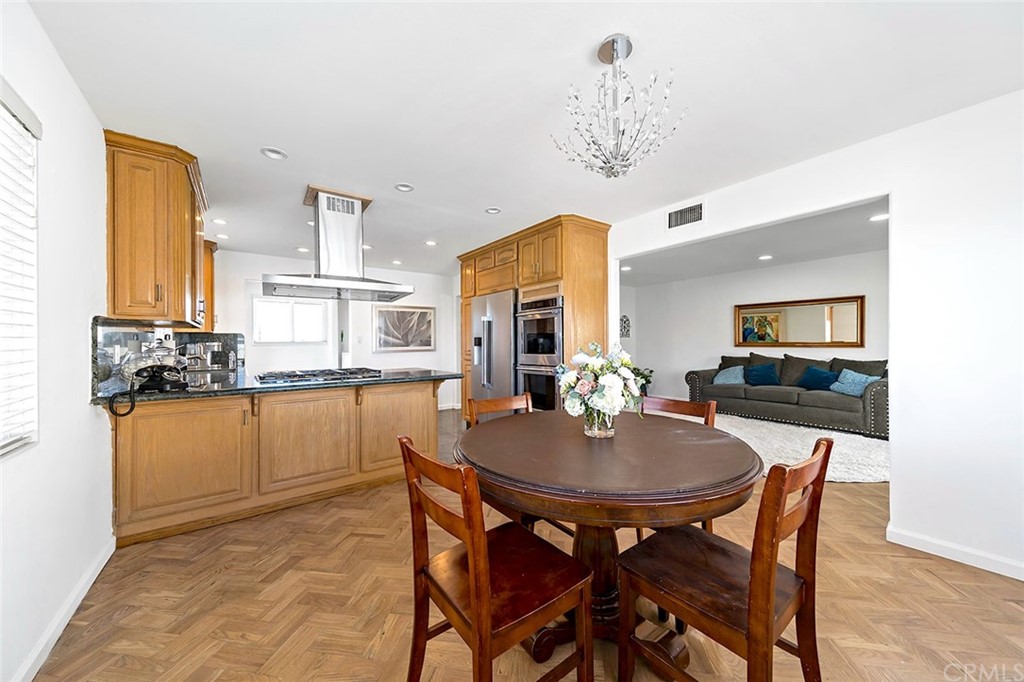 525 East 246th Street Carson, CA 90745 - Photo 13 of 41 a kitchen with stainless steel appliances granite countertop a dining table chairs and a refrigerator