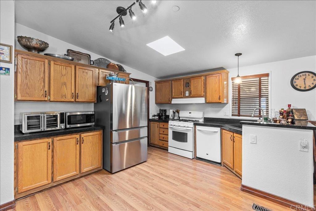 2285 Tierra Heights Road Boulevard, CA 91905 - Photo 12 of 51 a kitchen with granite countertop a refrigerator stove top oven and sink