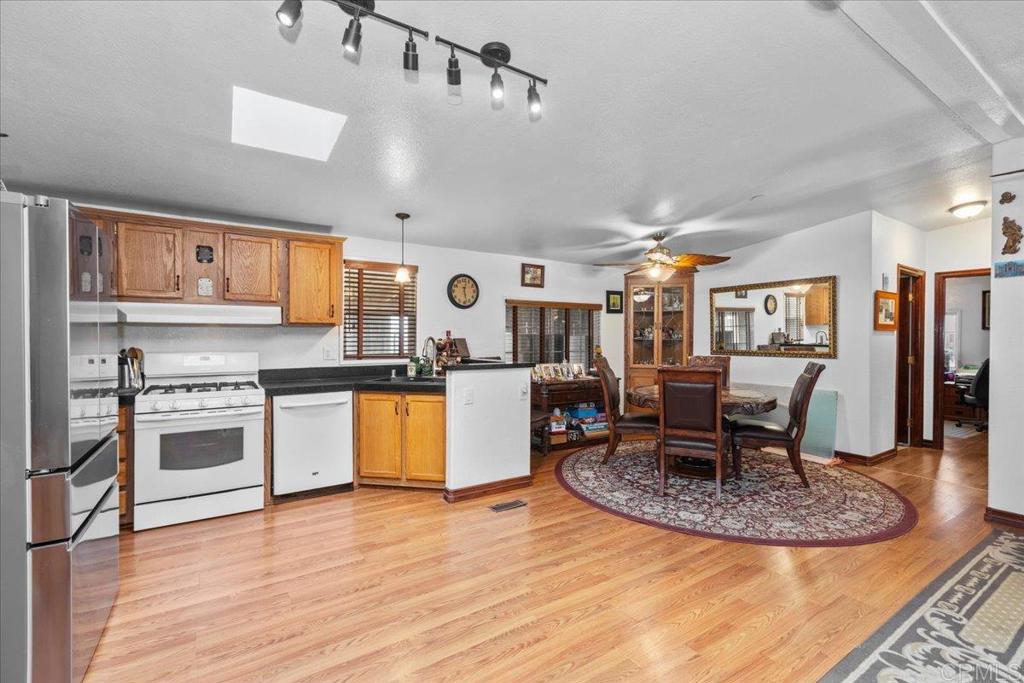 2285 Tierra Heights Road Boulevard, CA 91905 - Photo 13 of 51 a kitchen with stainless steel appliances granite countertop a stove top oven a sink a dining table and chairs with wooden floor