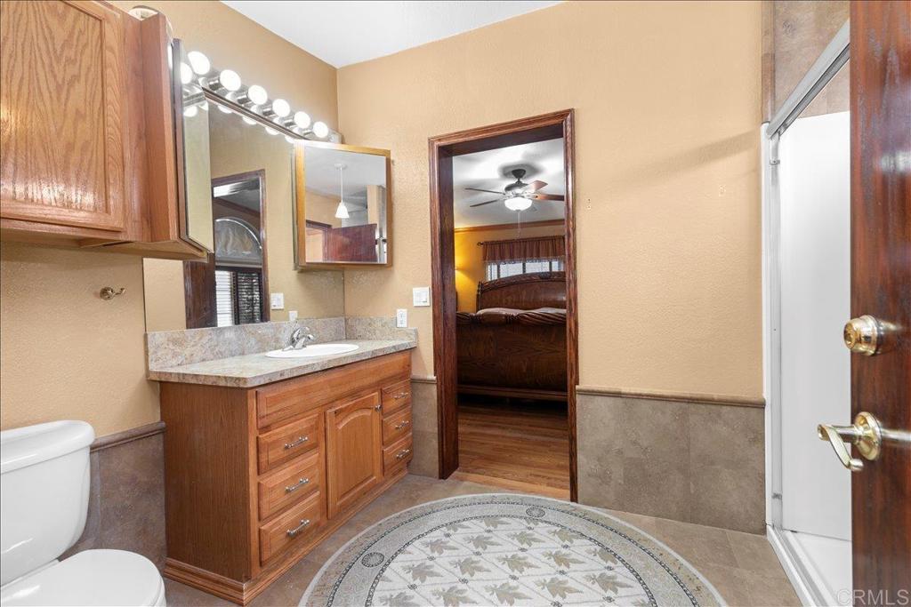 2285 Tierra Heights Road Boulevard, CA 91905 - Photo 19 of 51 a bathroom with a granite countertop sink a toilet and a shower