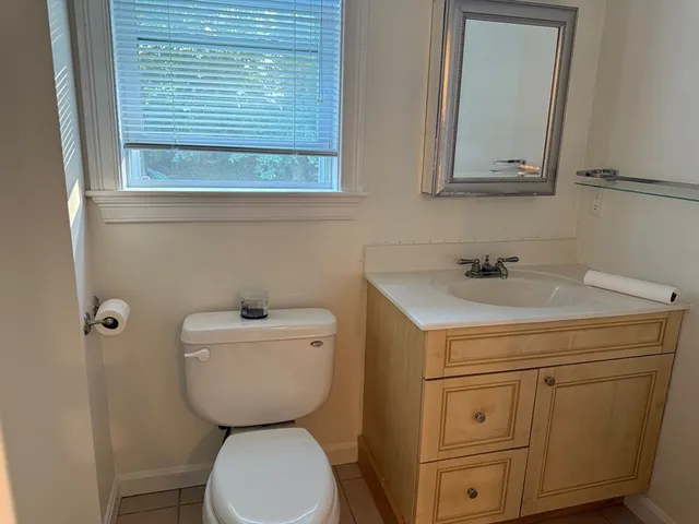 a bathroom with a toilet sink and mirror