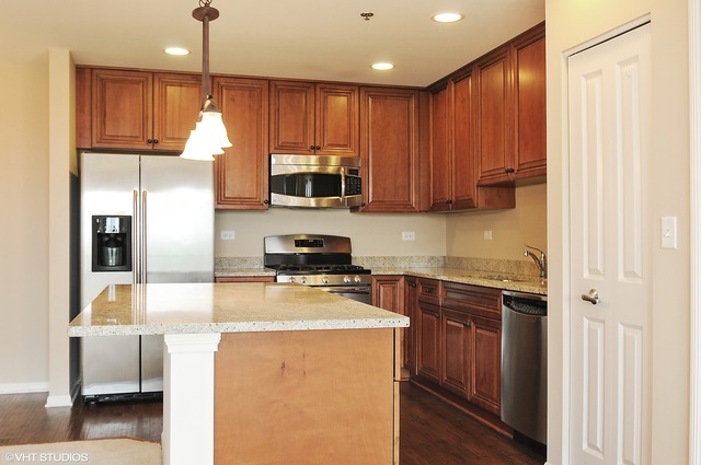 1199 East Port Clinton Road, Unit 208 Vernon Hills, IL 60061 - Photo 3 of 19 a kitchen with kitchen island granite countertop stainless steel appliances and wooden cabinets
