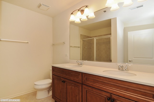 1199 East Port Clinton Road, Unit 208 Vernon Hills, IL 60061 - Photo 8 of 19 a bathroom with a granite countertop sink a toilet and a mirror
