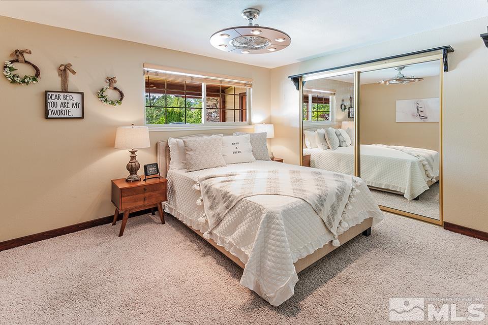 4190 Hackamore Drive Reno, NV 89519 - Photo 15 of 25 a spacious bedroom with a bed and a chandelier
