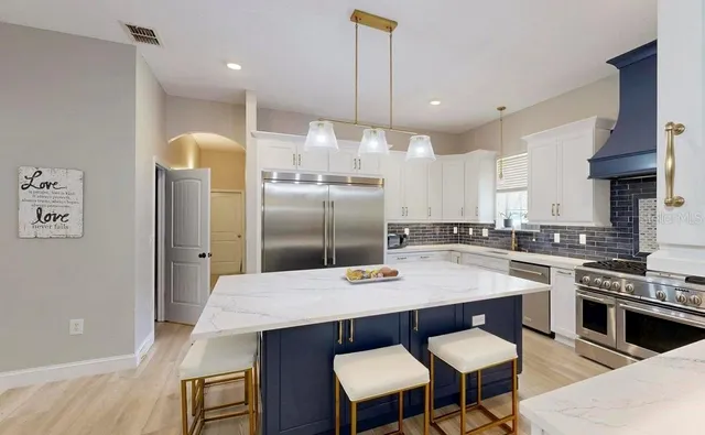 a dining room with furniture a chandelier and wooden floor