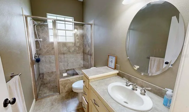 a view of a small house with a small yard and large trees