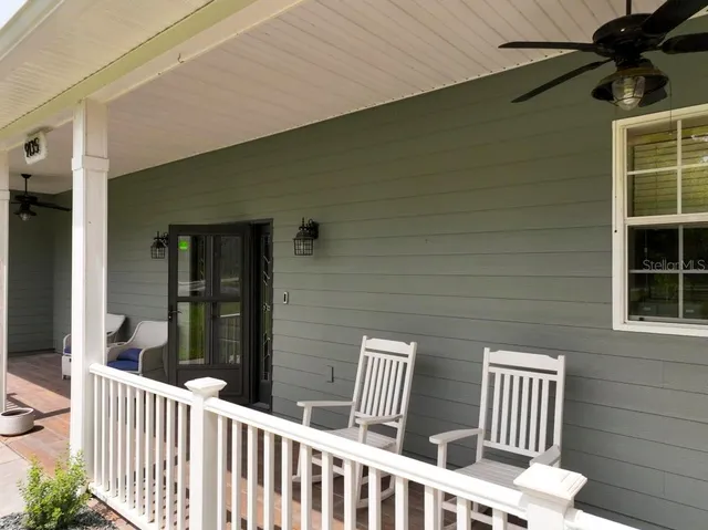 a kitchen with stainless steel appliances kitchen island granite countertop a dining table chairs and refrigerator