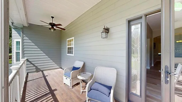 a kitchen with stainless steel appliances kitchen island granite countertop a refrigerator a stove a sink dishwasher and white cabinets with wooden floor