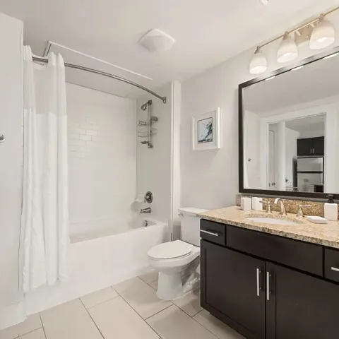 a bathroom with a double vanity sink toilet mirror and shower
