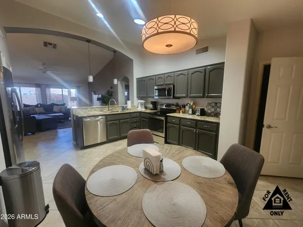 a kitchen with stainless steel appliances granite countertop a dining table and chairs