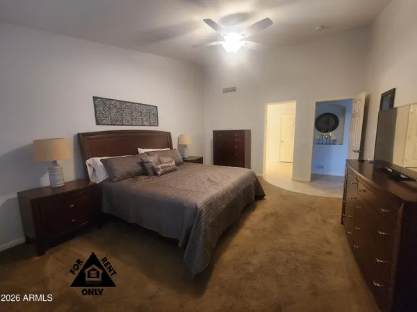a bedroom with a bed and a flat tv screen on dresser